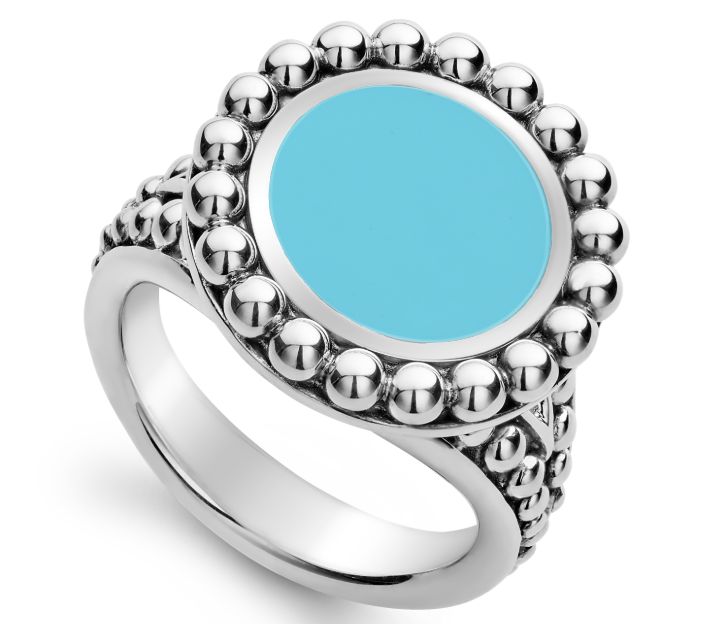 Top view looking down. A light blue ceramic center is halo by sterling silver beaded details. It is attached to a tapered sterling silver shank with additional beaded details decorating the shoulders of the ring.