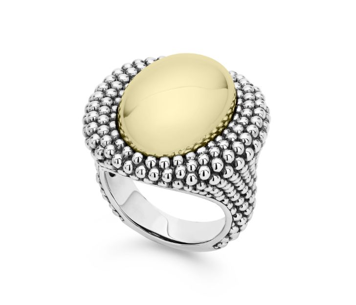 Front view of ring. A polished yellow gold, oval, domed center is haloed by a double layer of beaded sterling silver. Additional beaded details accent a thick, tapered shank.
