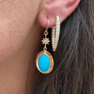 gold and turquoise drop earrings and gold diamond hoop earring on model