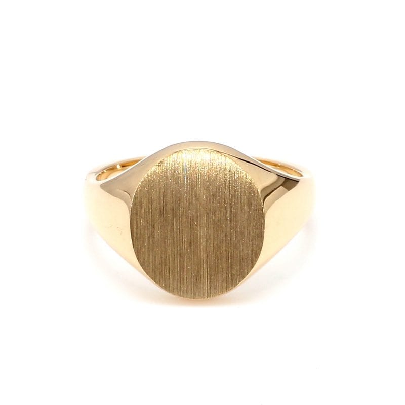 Front view of ring. A 14k yellow gold signet ring has an oval face and is finished with a brushed texture. It is attached to a polished yellow gold shank.