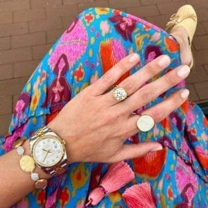 gold and diamond jewelry on wrist & Hand over multi color womens dress