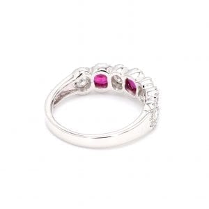 135 degree angle of ring. A simple white gold band leads to a seven stone setting that holds three oval rubies and four round brilliant cut diamonds, framed by scalloped pave diamond edges.
