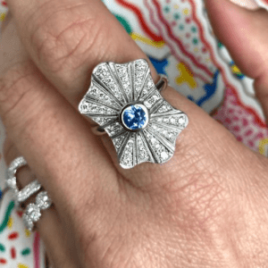 silver, diamond, and sapphire ring on colorful background