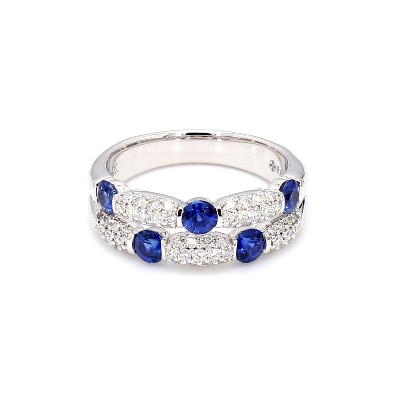 Front view of ring. Two rows of diamonds and sapphires are offset from each other. The top row has three round sapphires with pave diamond stations in between each. The second row has three pave diamond stations with two sapphires in between each.
