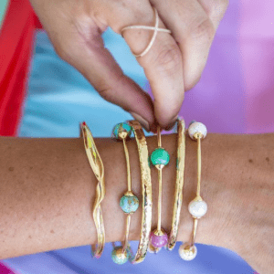 gold and colored stone bracelets on model