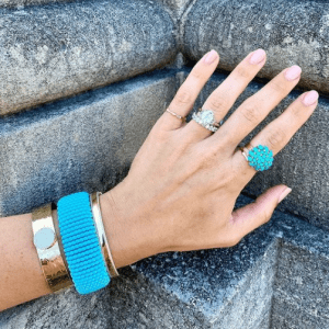 gold and turquoise rings and bracelets on model
