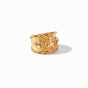 45 degree angle of ring. A tapered, open shank is decorated with a coin crest detail of a pegasus. Three cubic zirconia are studded in a triangular formation on each side. Beaded details line the edges of this ring and halo the coin crest.