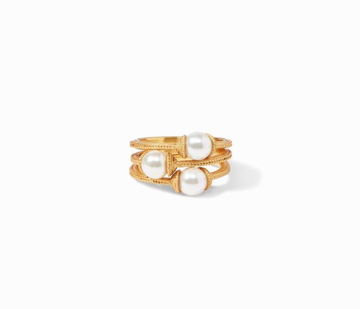 Front view of ring. A set of three. Three stackable rings feature a textured gold plated band with a pearl in the center.
