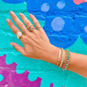 gold and turquoise rings and bracelets on model