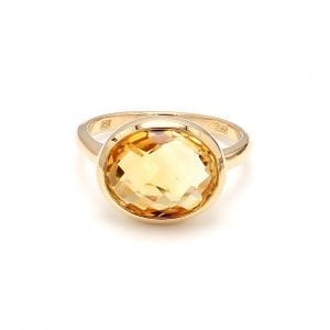 360 imaging of ring. A polished yellow gold shank boasts a briolette cut oval citrine, set east to west.