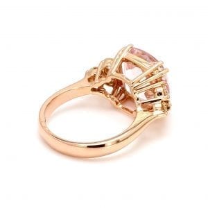 135 degree angle of ring. A simple rose gold shank leads to a cushion shaped setting with shoulders that hold three round brilliant cut diamonds in the shape of a side triangle.