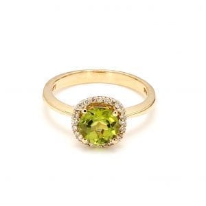 360 imaging of ring. A polished yellow gold shank leads to the gallery that is cut out with floral scrolls. The head of the ring sets a light green peridot in the center with a diamond halo surrounding it.