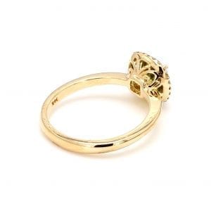 135 degree angle of ring. A polished yellow gold shank leads to the gallery that is cut out with floral scrolls. The head of the ring sets a light green peridot in the center with a diamond halo surrounding it.