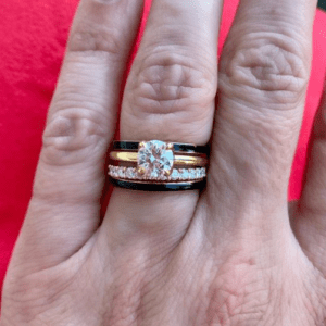 diamond ring and black rings stacked and worn on ring finger