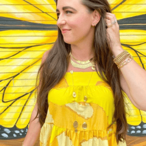 gold necklaces and bracelets on model with yellow background