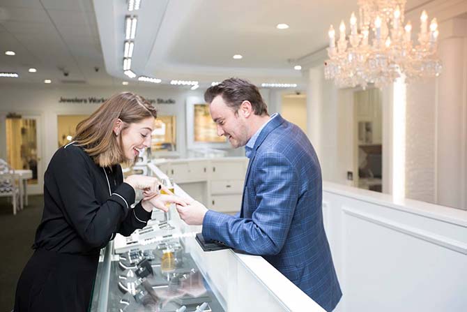 woman looking at a wedding ring with help from a jeweler