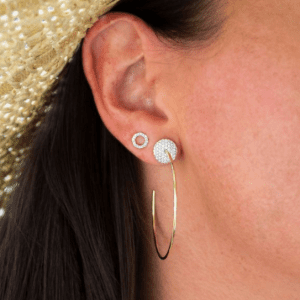 two gold and diamond earrings on model