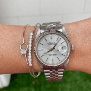 silver watch and silver and diamond bracelets on wrist
