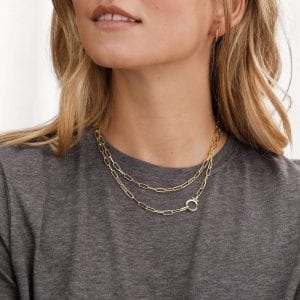 Woman with blonde hair and gray shirt wearing Gorjana Parker paper clip chain necklace.