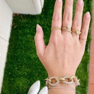 gold rings on hand over grass