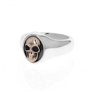 side angle view of silver mens signet ring with gold skull