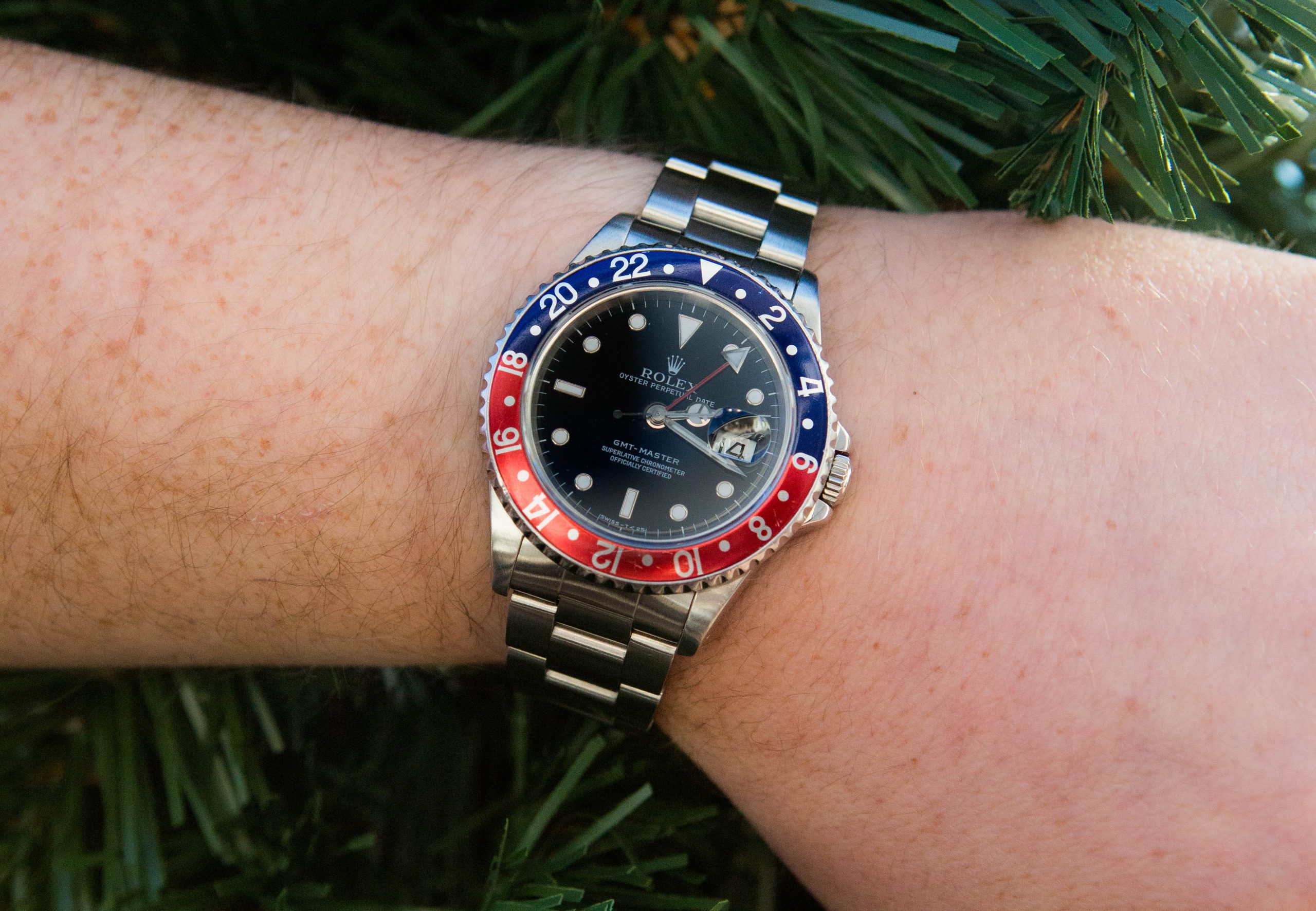 Rolex Pepsi on wrist with green background. 